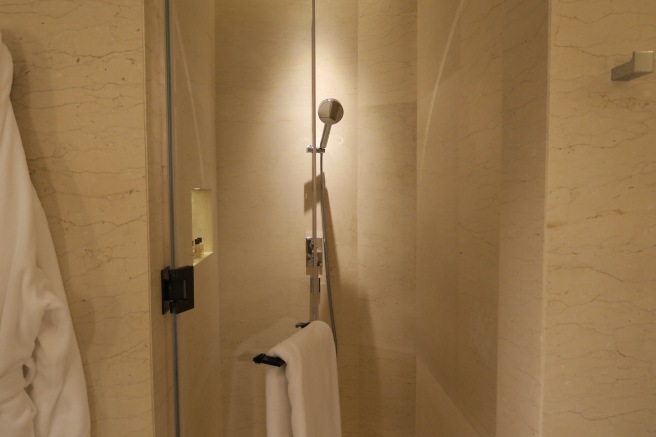 a shower with a towel on the wall