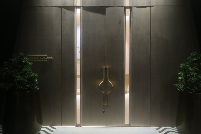 a large wooden door with a gold handle