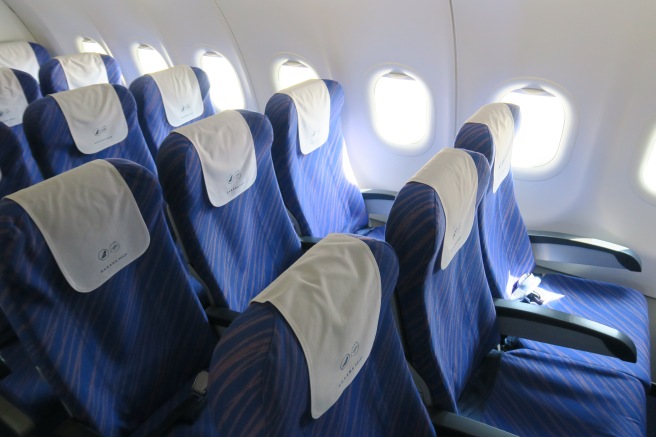 a row of blue seats with white sheets on them