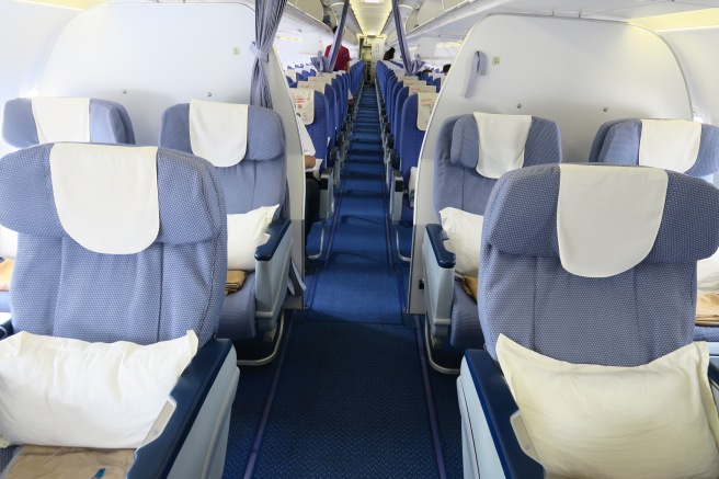 the inside of an airplane with blue seats