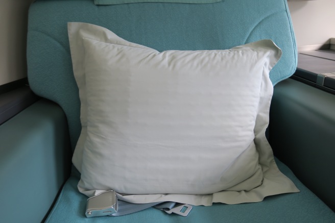 a white pillow on a blue chair