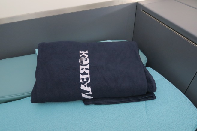 a folded blanket on a blue bed