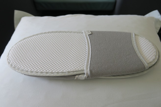 a white and grey slipper on a white surface