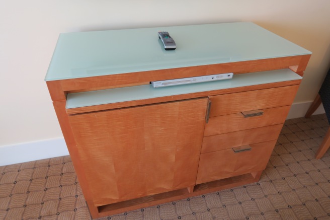 a wooden dresser with a remote control