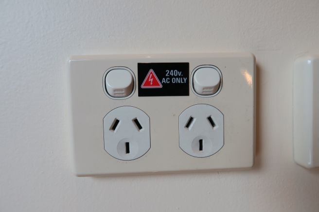 a white electrical outlet with buttons and a red triangle