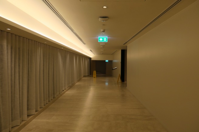 a long hallway with a green sign
