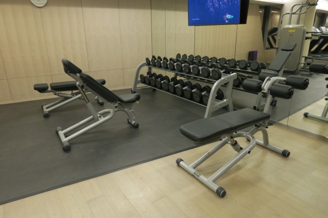 a gym with weights and a large display