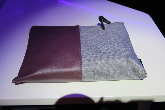 a purple and grey bag on a white surface