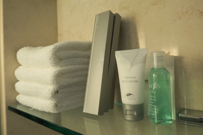 a stack of towels and a few bottles of body lotion