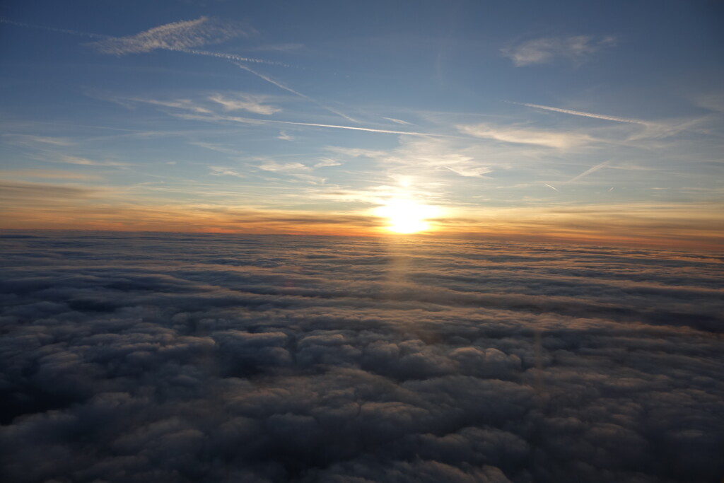 a sun setting over clouds