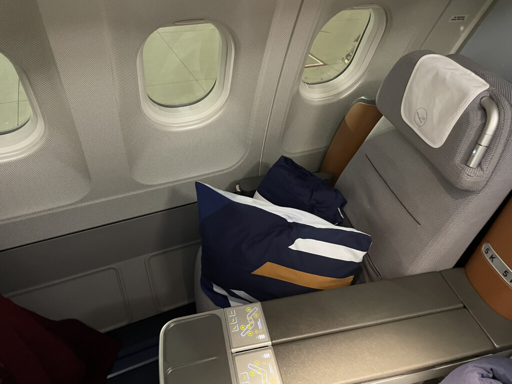 a seat with pillows and a table in the middle of a plane