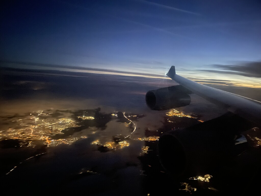 an airplane wing and lights in the sky