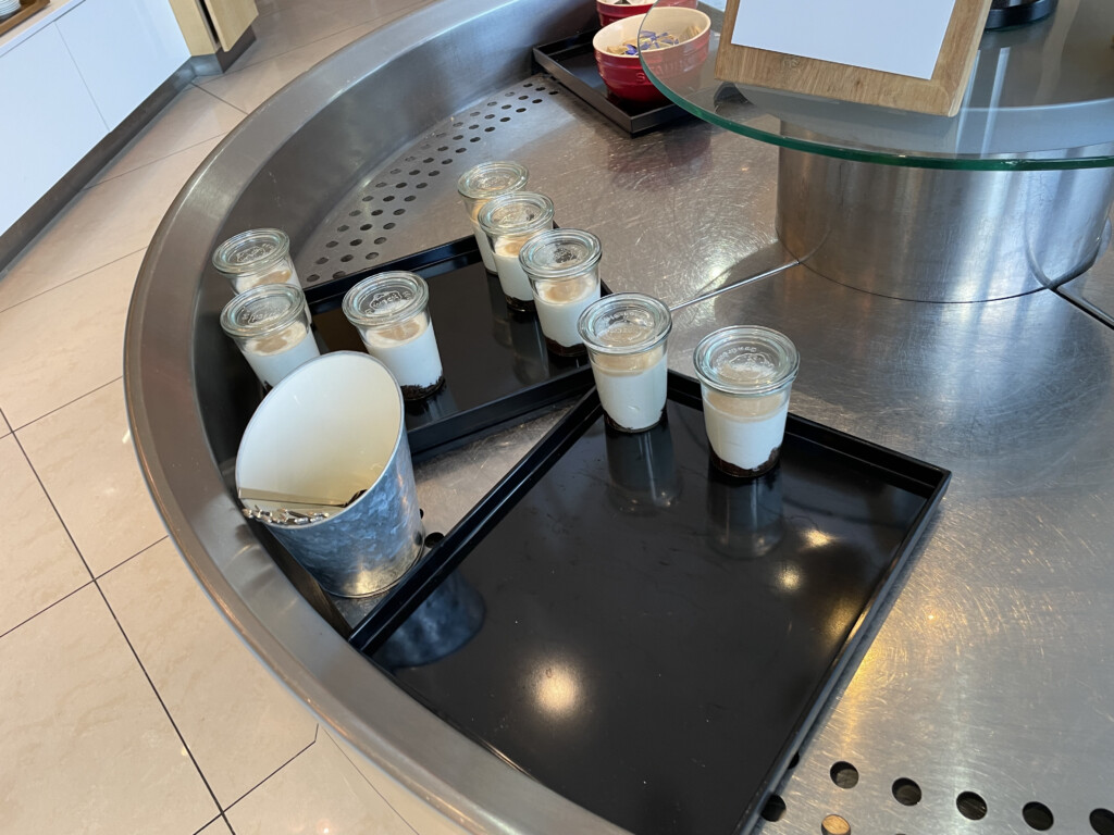 a group of glasses of dessert on a tray