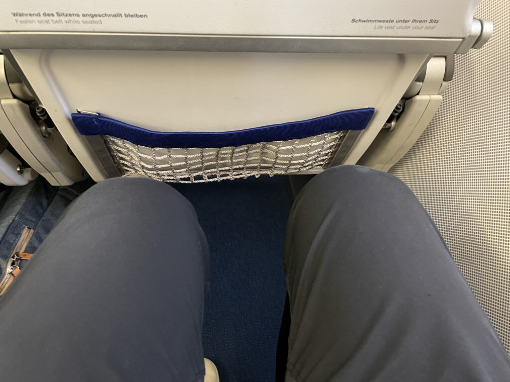 a person's legs in a net on an airplane
