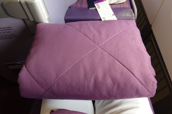 a purple pillow on a bed