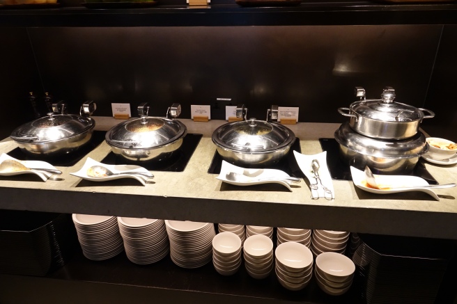 a row of silver pots and bowls on a counter