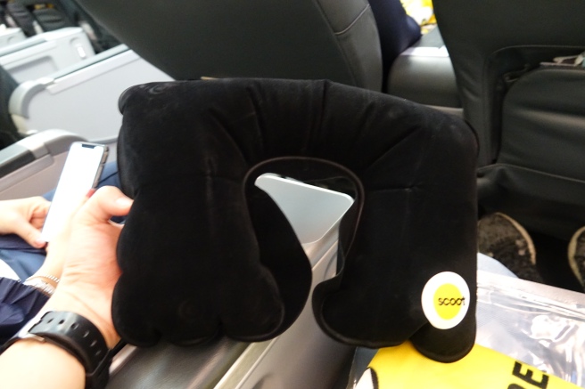 a black neck pillow with a yellow label