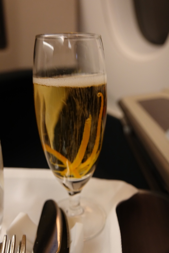 a glass of champagne with orange peels in it