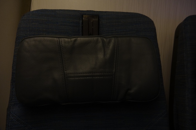 a black leather bag on a blue fabric chair