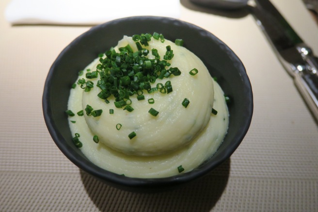 a bowl of mashed potatoes with green onions