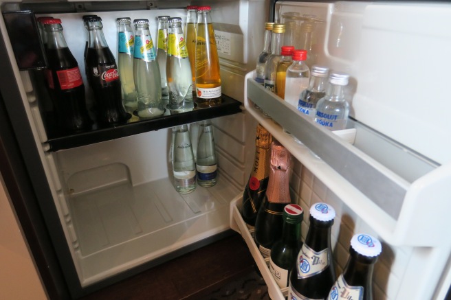 a refrigerator full of bottles of soda and other beverages