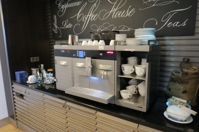 a coffee machine with cups on shelves