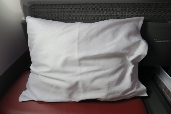 a white pillow on a red seat