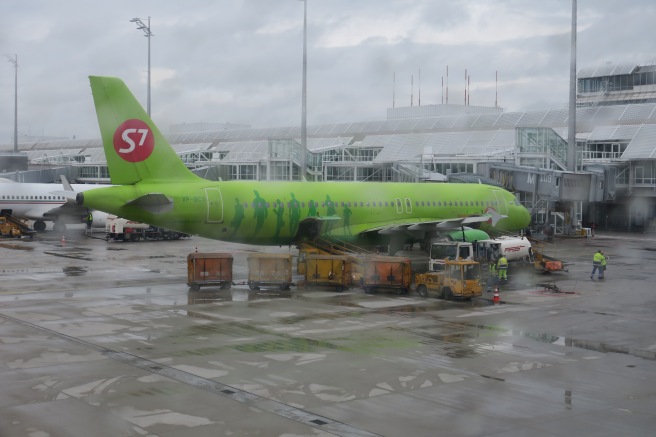 a green airplane in an airport