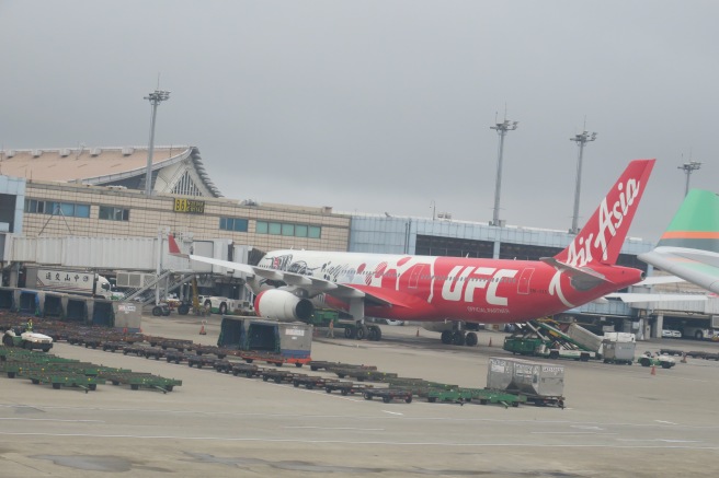 a red and white airplane at an airport