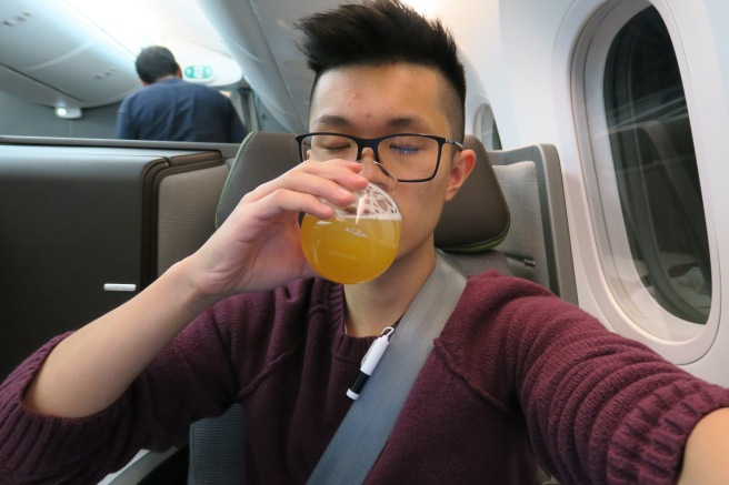 a man drinking from a glass on an airplane