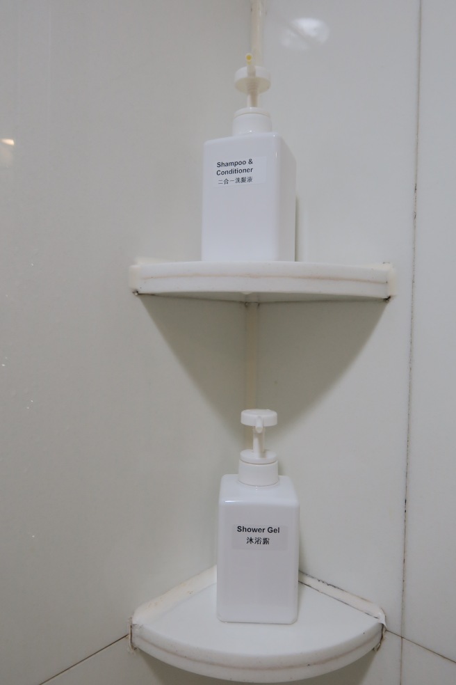 a white bottles of soap and shampoo on a white shelf