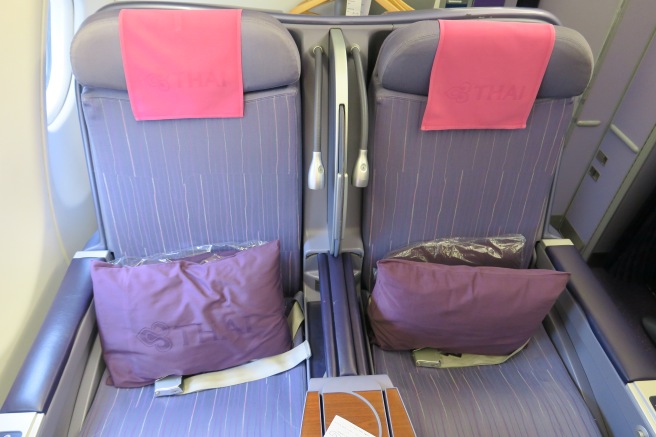 a seat with purple pillows and a pink pillow on it
