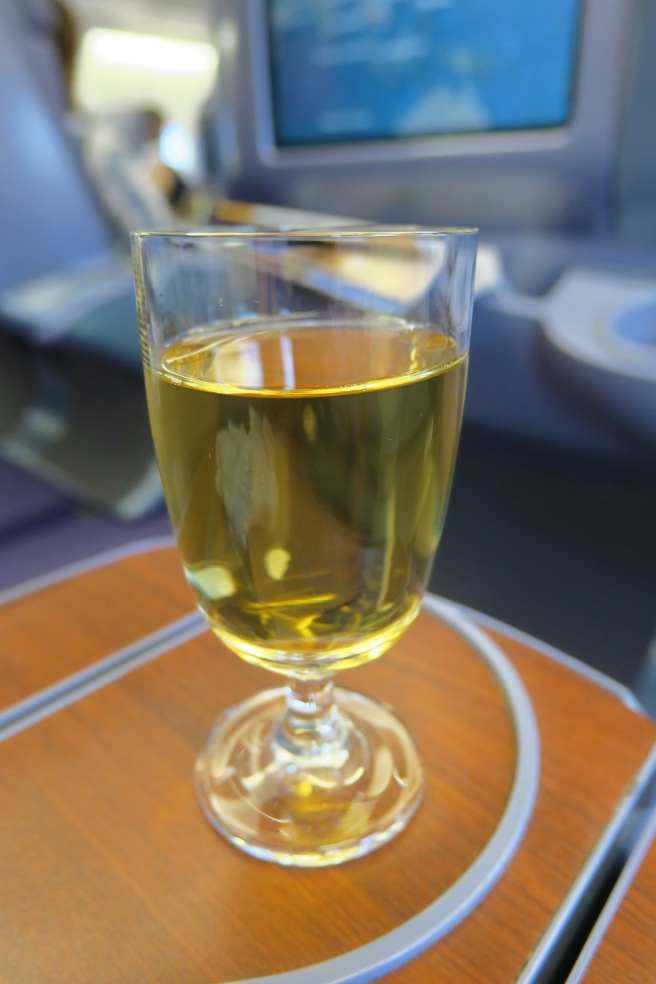 a glass of yellow liquid on a table
