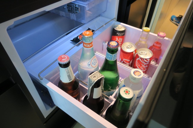 a open refrigerator with bottles of soda and pop