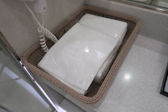 a basket with white towels in it