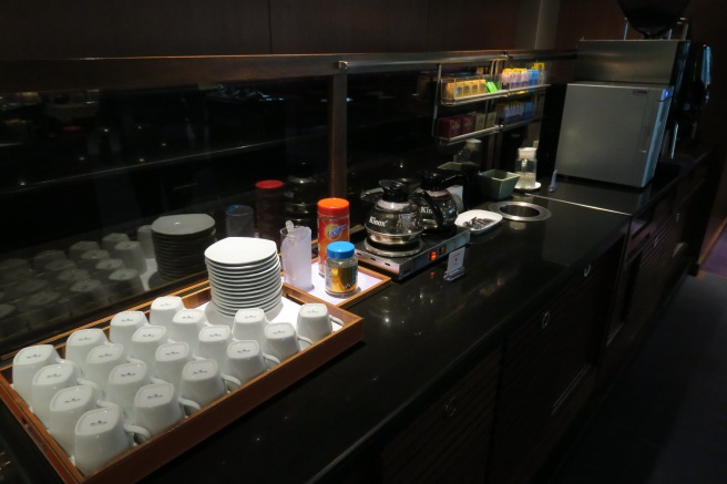 a counter with a tray of coffee cups and saucers