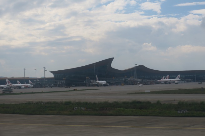 a large building with a curved roof and planes in the background