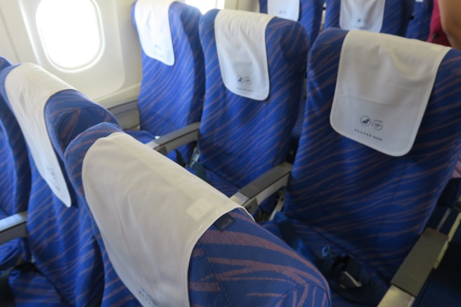 a row of blue chairs with white cloth on them