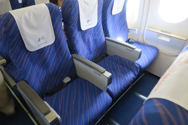 a row of blue seats with white towels on them
