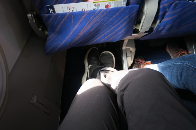 a person's legs and feet in the airplane