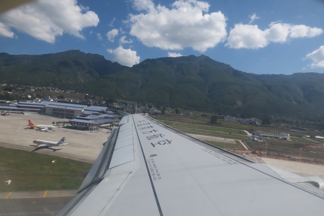 an airplane wing with mountains in the background