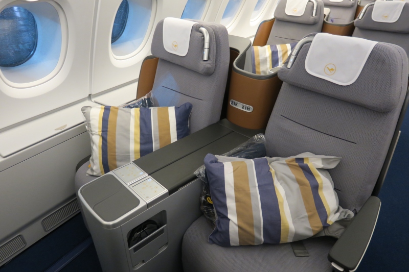 a seat with pillows on the side of the plane