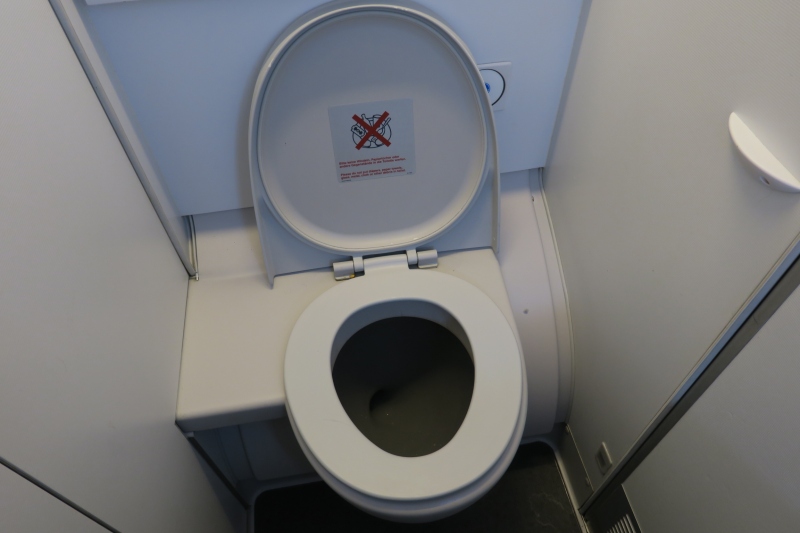 a toilet with a sign on the lid