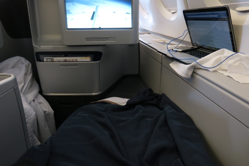 a laptop on a bed in an airplane