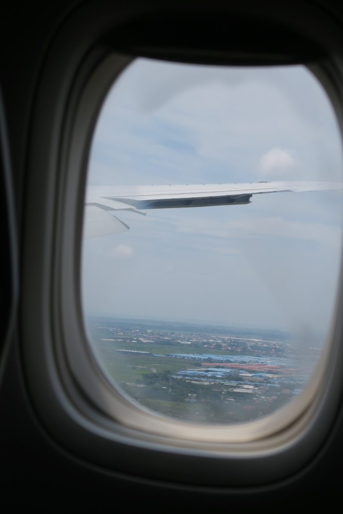 an airplane window with a view of a city and land