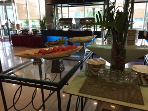 a buffet table with plates of fruit and glasses