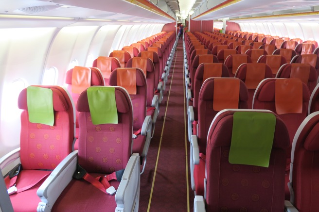 rows of red and orange seats on an airplane