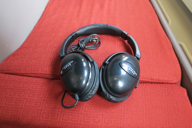 a pair of black headphones on a red surface