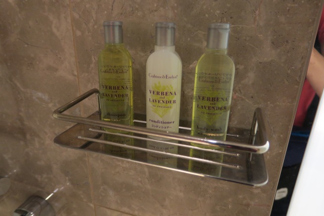 a group of bottles of shampoo and conditioner on a metal shelf