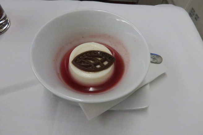 a white and brown dessert in a bowl of red liquid